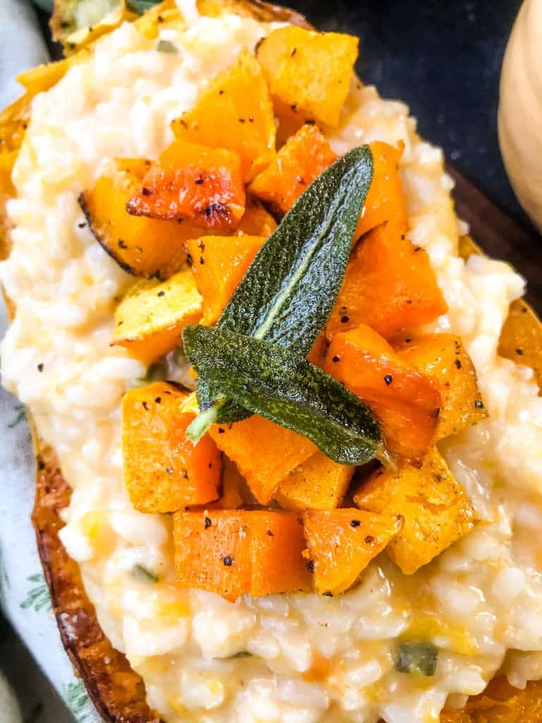 A close up of Butternut Squash Sage Risotto in a squash shell with sage on top