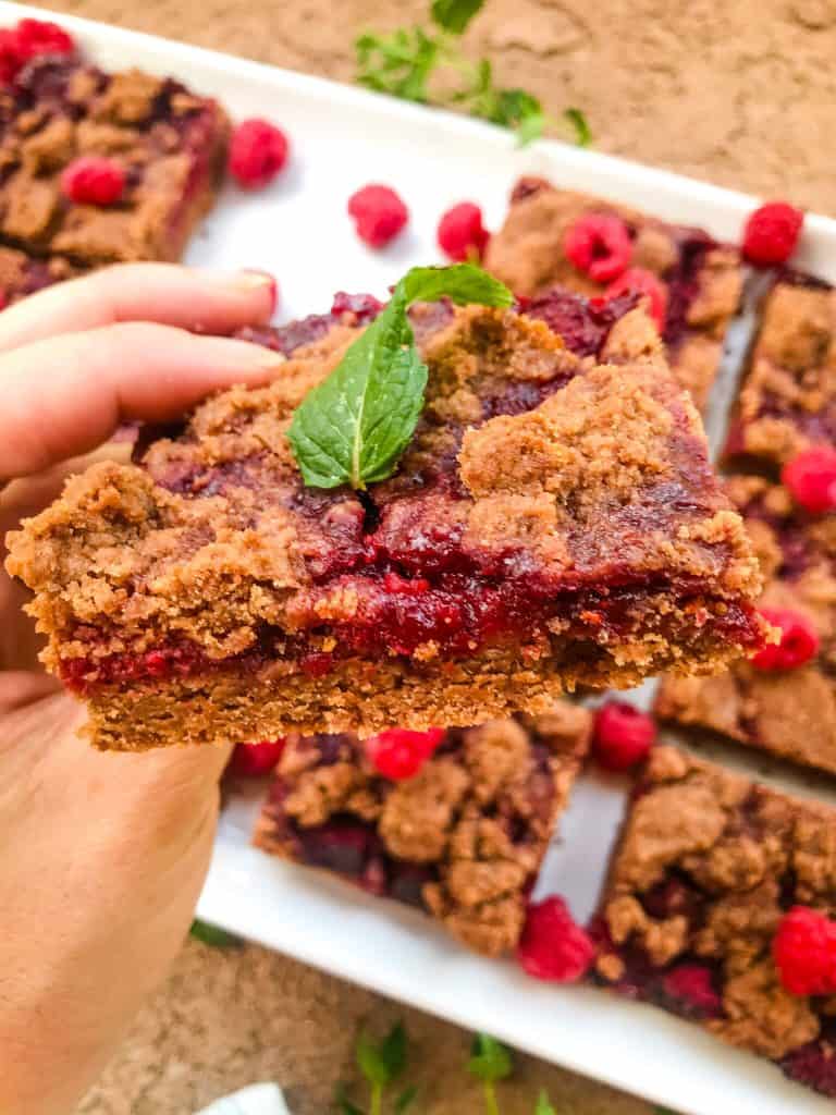 A hand holding a cookie bar looking at the layers