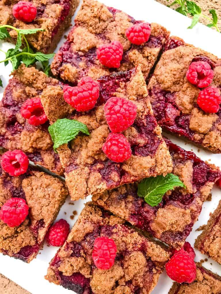 A stack of the Chocolate Raspberry Crumble Bars with fresh berries