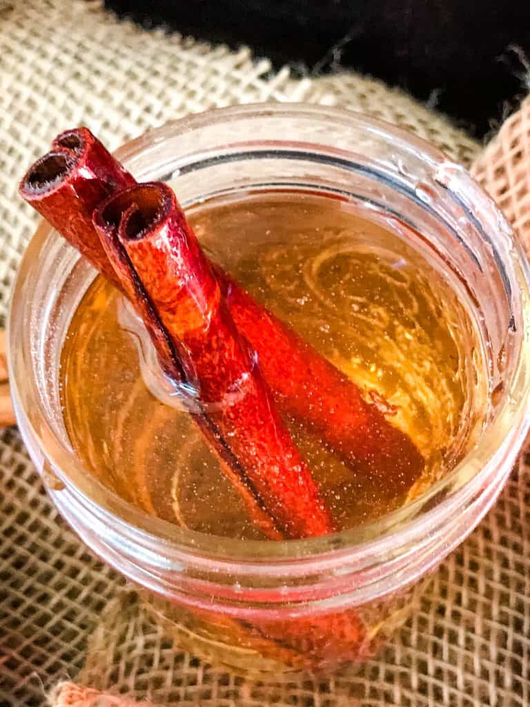 Close up of Cinnamon Simple Syrup with cinnamon sticks in a jar