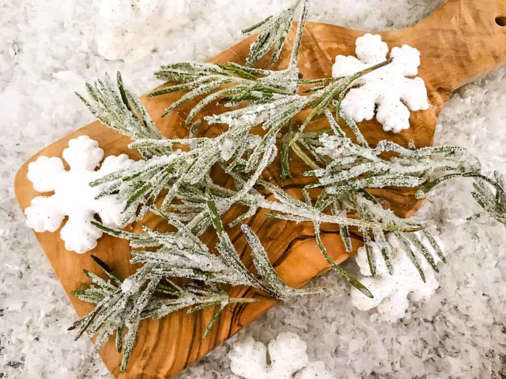 Sparkling Rosemary (Sugared Rosemary) on a cutting board with snow around it