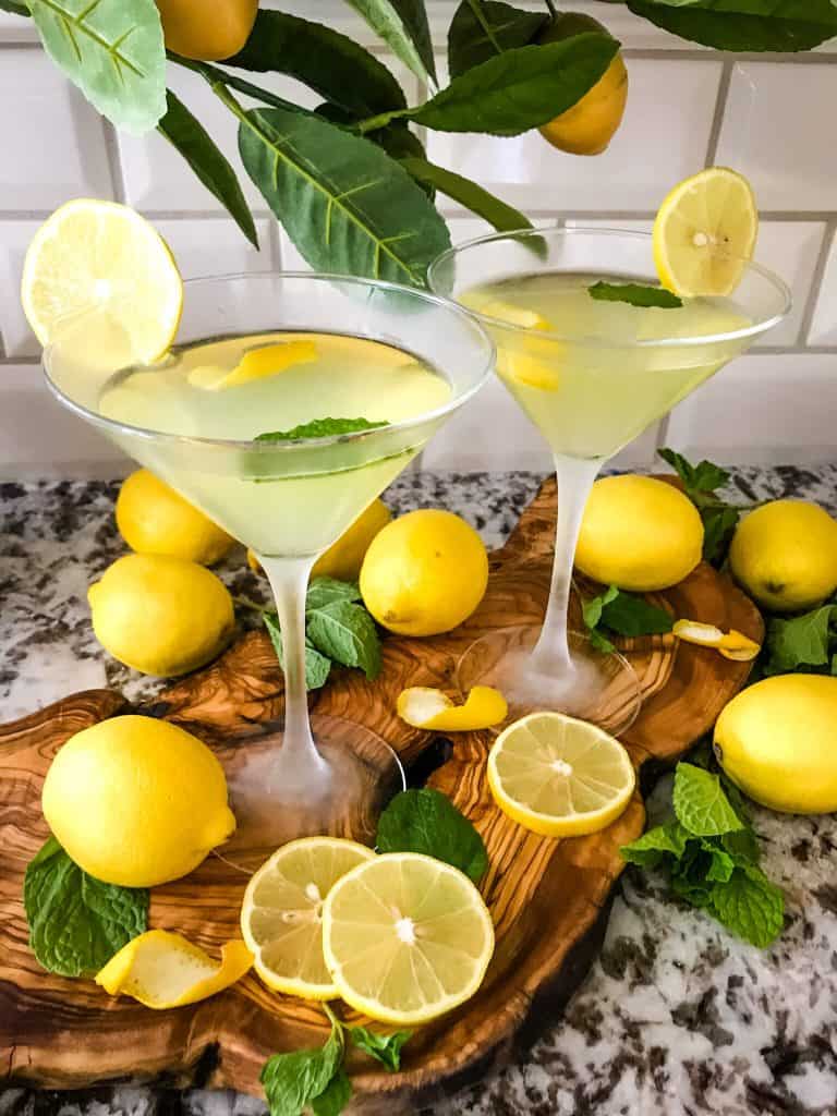 Italian lemon cocktails with lemons around them on a wood board
