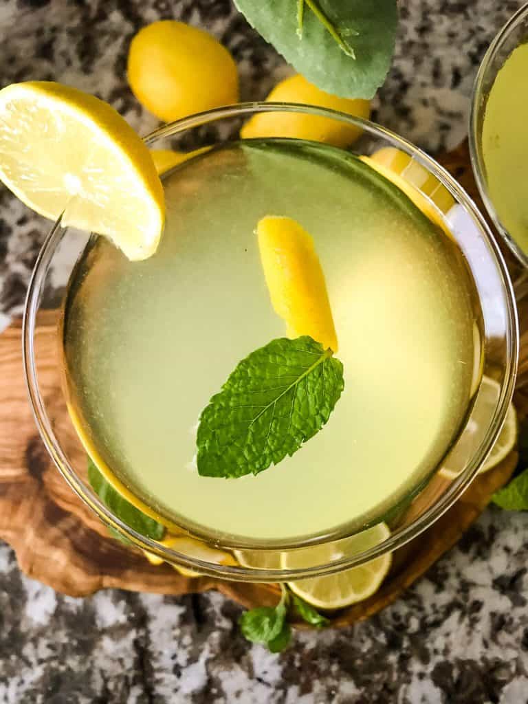 Top view of a martini with lemon and mint floating in it