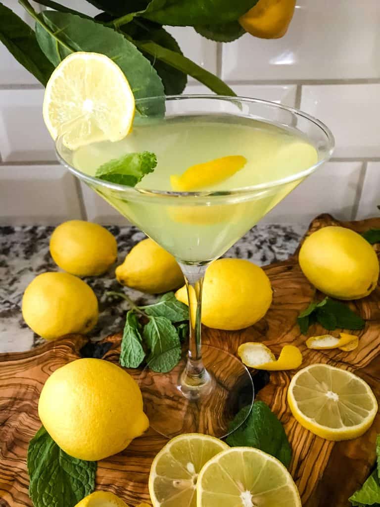 A martini glass full of Amalfi Martini Limoncello surrounded by lemons and mint