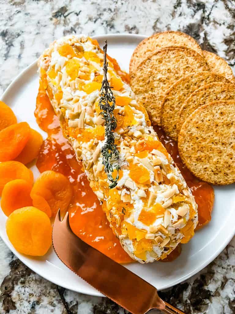 Apricot Almond Goat Cheese Log with dried apricots and crackers on a plate