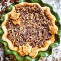 View of an entire Chocolate Bourbon Pecan Pie from the top in a green dish