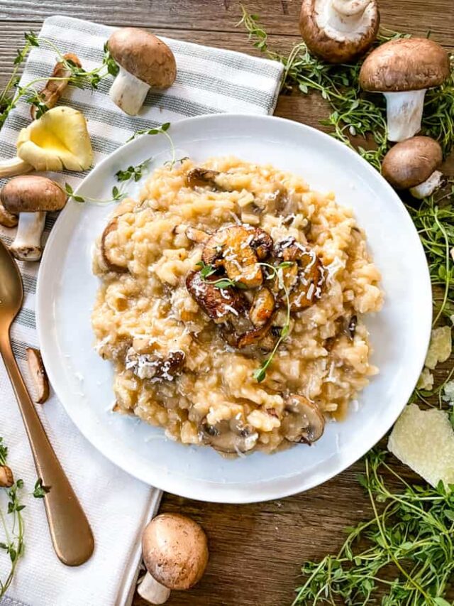 Creamy Mushroom Risotto on a white plate surrounded by mushrooms and fresh thyme