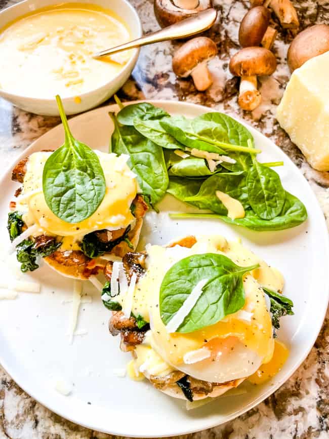 Two stacks of Eggs Florentine Benedict from the top on a white round plate