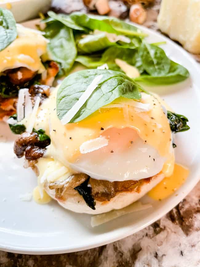 Close up of a stack of Eggs Florentine Benedict on a white plate