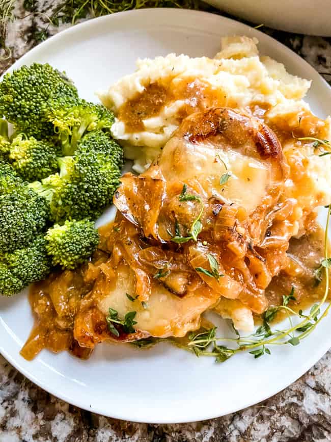 Top view of a pork chop with potatoes and broccoli on a plate