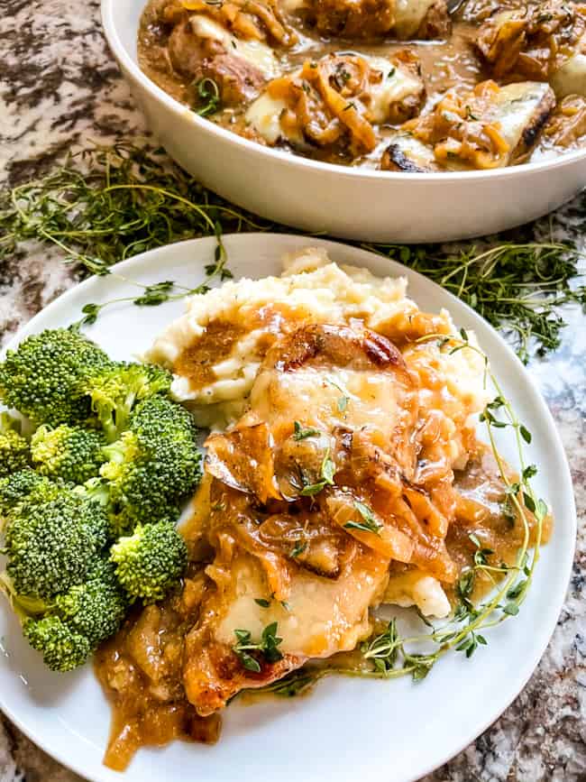 Serving up French Onion Pork Chops on a plate with sides