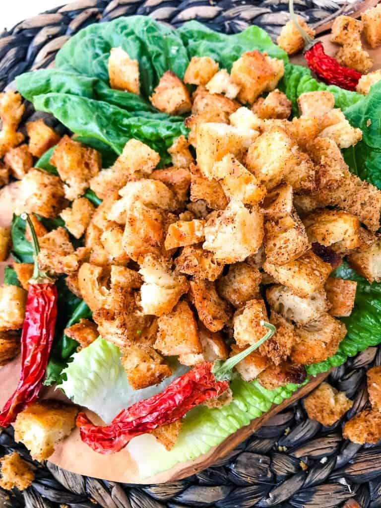 A pile of Homemade Mexican Croutons on top of lettuce