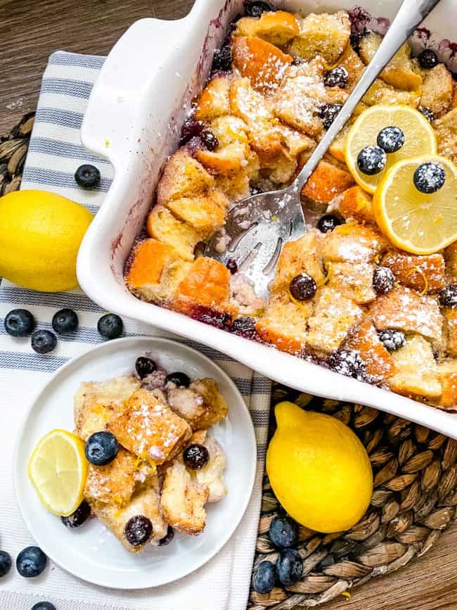 A dish of Lemon Blueberry Bread Pudding with a plate of it next to it