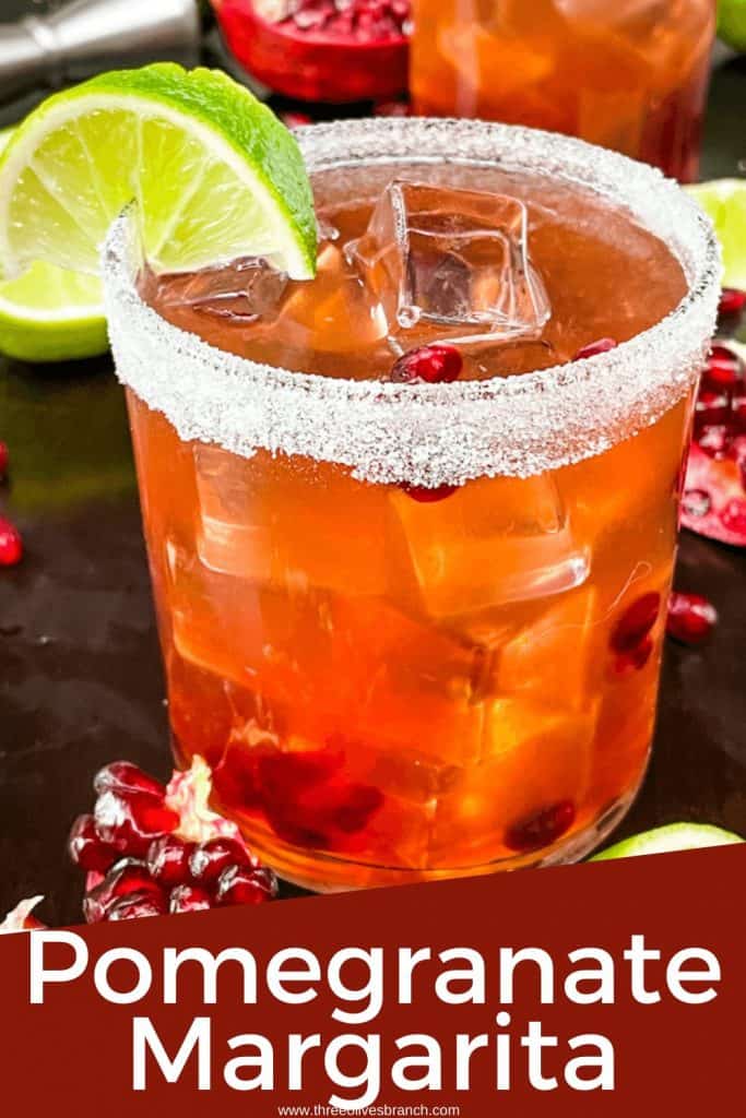 Pin image for Pomegranate Margarita with a short glass filled with the red tequila cocktail, a sugar rim, and a lime wedge with title at bottom