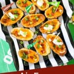 Classic filled Air Fryer Potato Skins with cheddar, bacon, chives, and sour cream on a football tray with title at bottom