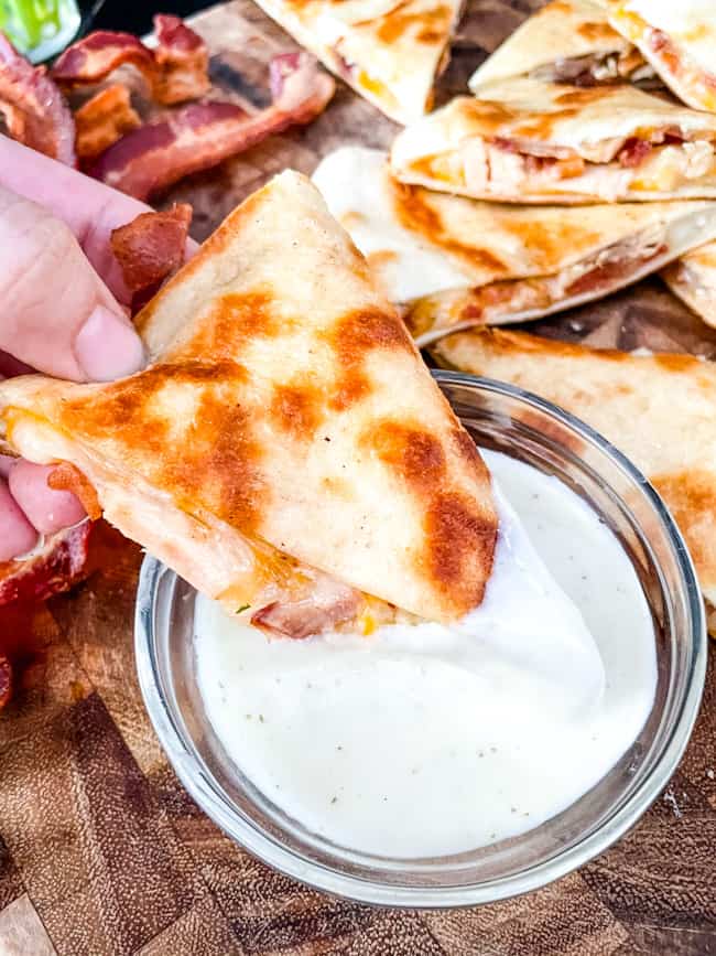 Chicken Bacon Ranch Quesadilla being dunked into ranch