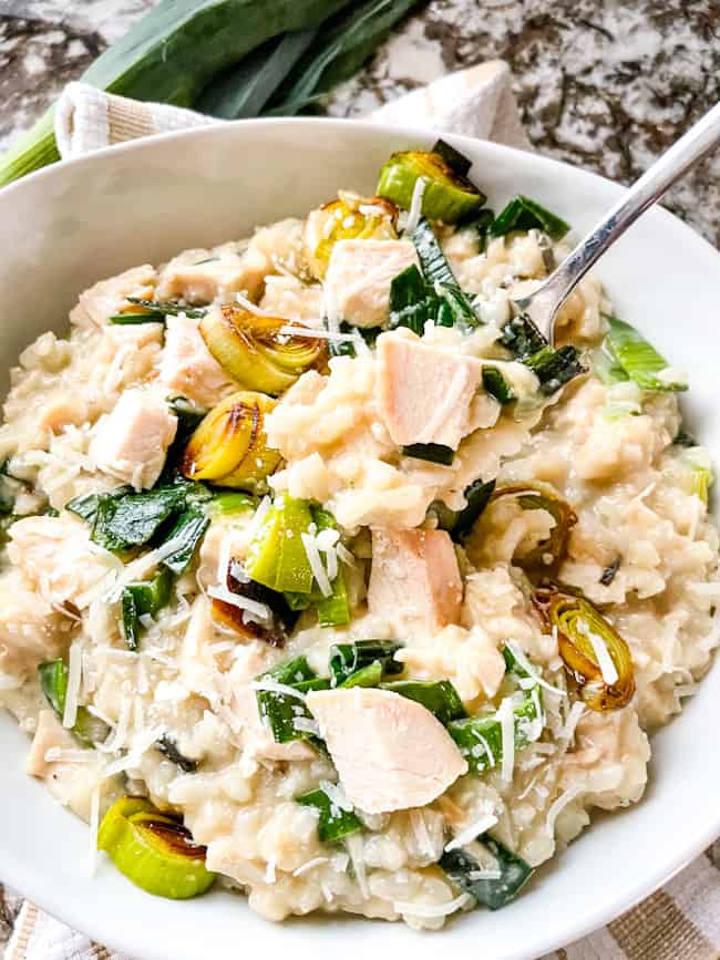 A fork digging into a bowl of Chicken and Leek Risotto