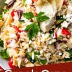 Pin image of Greek Orzo Salad in a bowl with artichoke heart on top and title at bottom