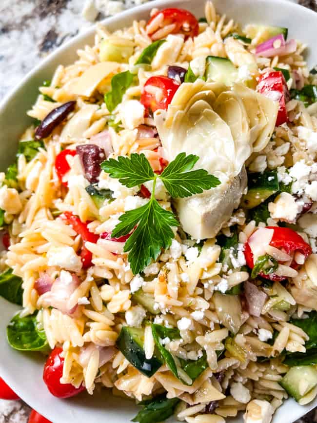 A bowl of Mediterranean vegetables mixed with the pasta and spinach