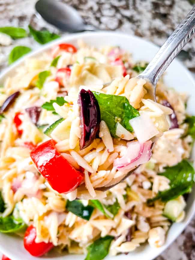 A spoon of Greek Orzo Salad