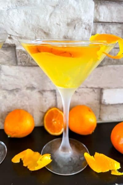 An Orange Martini with oranges around it