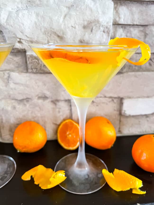 An Orange Martini with oranges around it