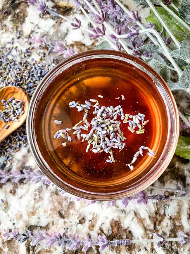 Top view of a bowl of Lavender Syrup Recipe with some lavender on top and around it