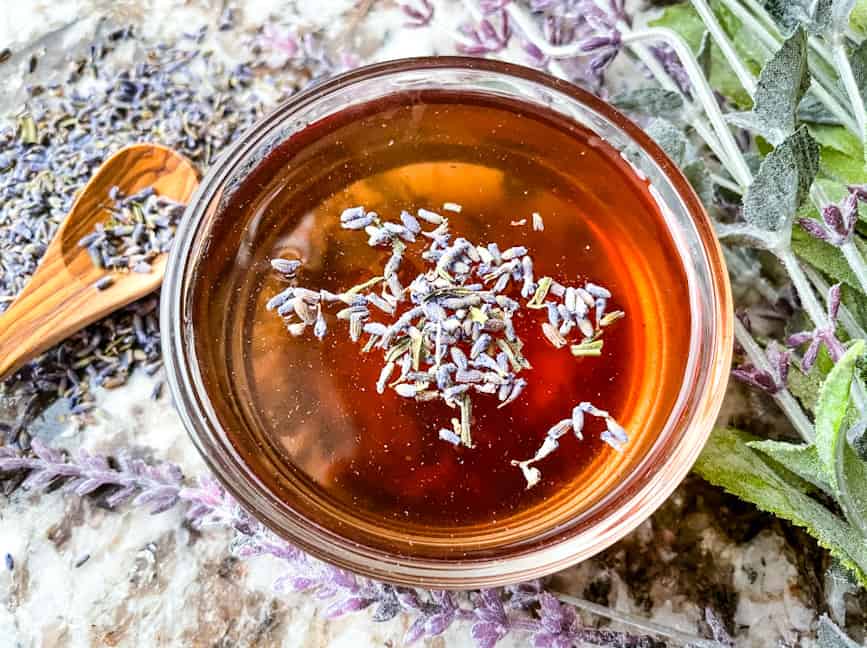 Lavender Syrup Recipe in a bowl with lavender around it