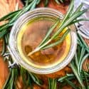 Some Rosemary Simple Syrup in a jar with rosemary around it