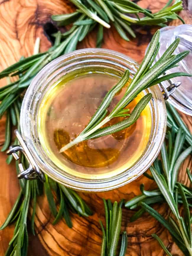 Some Rosemary Simple Syrup in a jar with rosemary around it