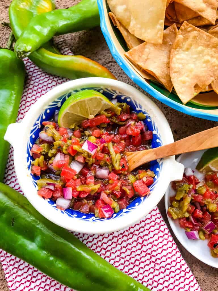 A bowl of the salsa with a wooden spoon