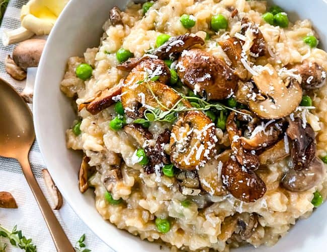 Mushroom Pea Risotto in a bowl on top of a towel