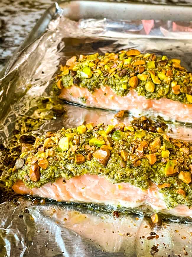 Two pieces of coated fish on a pan after cooking