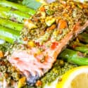 Pesto Crusted Salmon partially eaten on top of asparagus