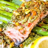 Pesto Crusted Salmon partially eaten on top of asparagus