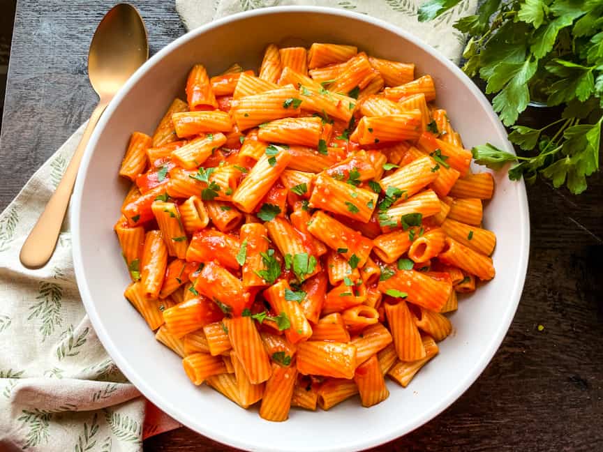 A bowl of the pasta on a towel with a spoon