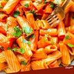 Pin image of a fork digging into Rigatoni Arrabbiata with title at bottom