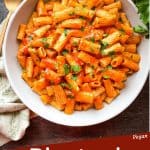 Pin image of a bowl of Rigatoni Arrabbiata on a towel with title at bottom