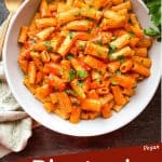 Pin image of a bowl of Rigatoni Arrabbiata on a towel with title at bottom