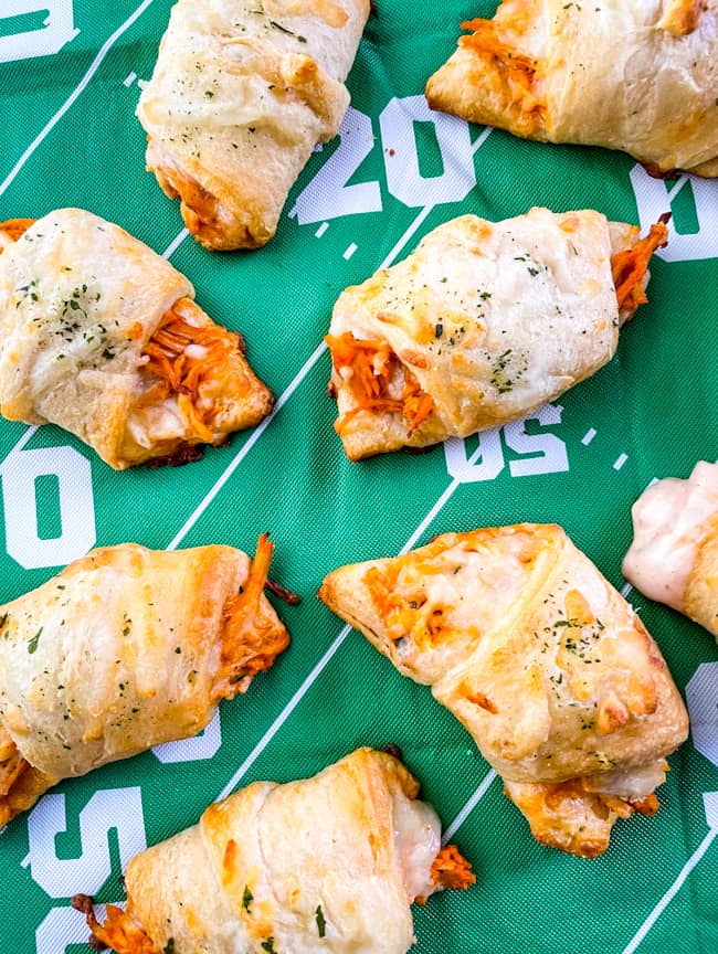 Buffalo Chicken Crescent Rolls scattered on a football field tablecloth