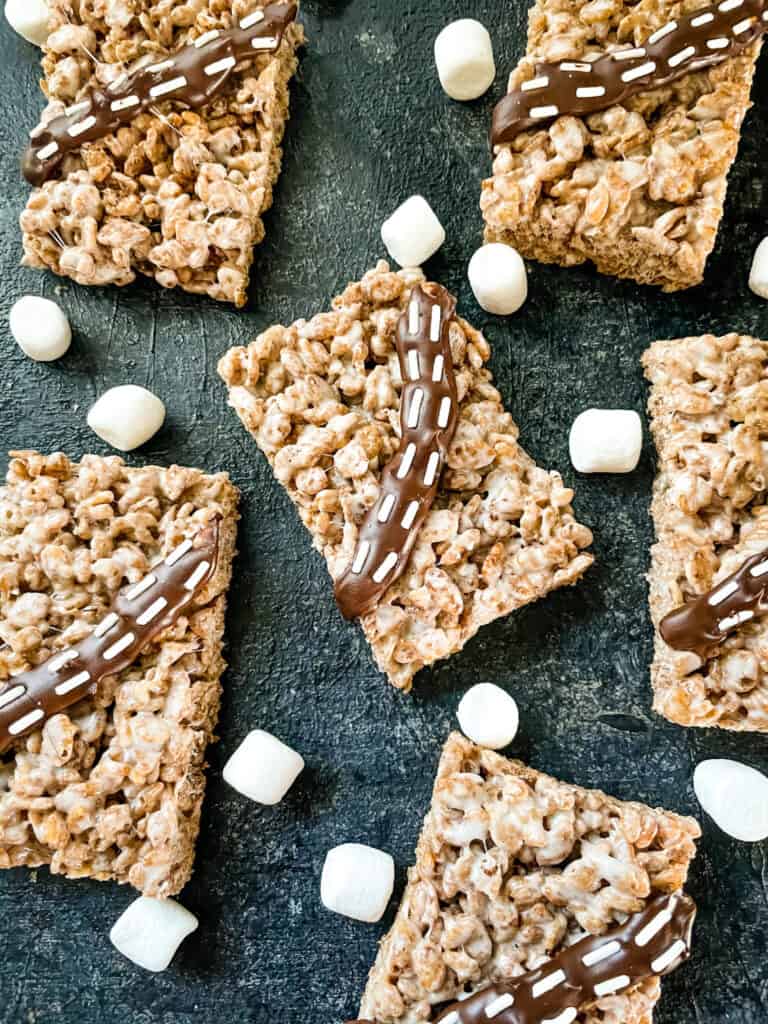 Serveral cereal bars on a black board with marshmallows