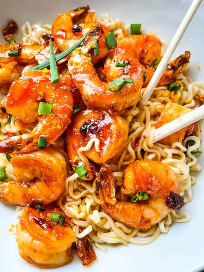 Chipotle Orange Glazed Shrimp in a bowl on top of ramen noodles with chopsticks