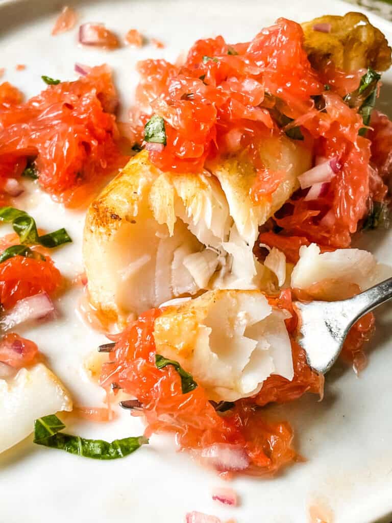 A fork digging into Cod with Grapefruit Relish