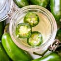 Top view of Jalapeno Simple Syrup in a jar with jalapenos around it