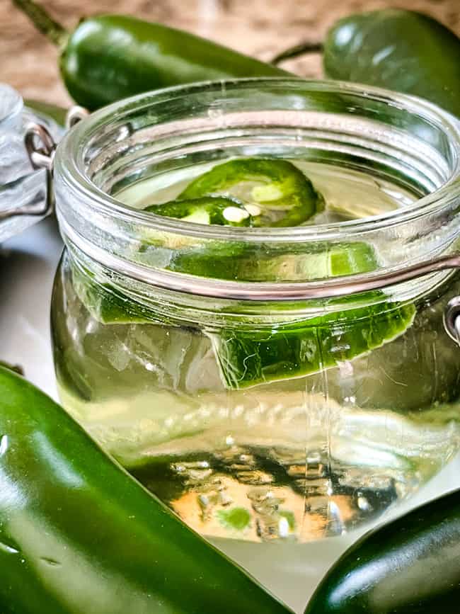 Close up side view of Jalapeno Simple Syrup in a clear jar
