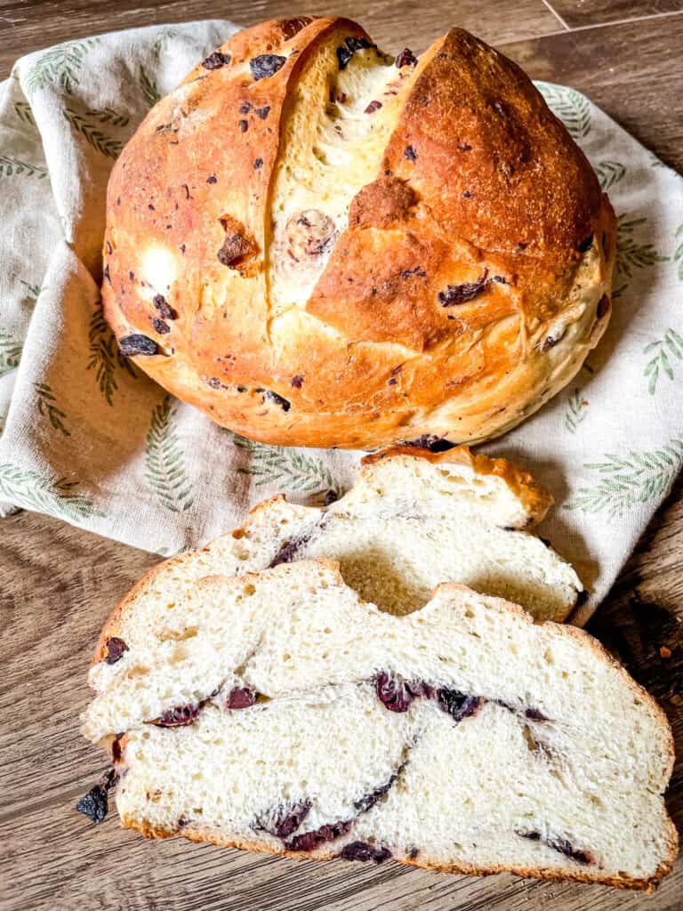 A Sourdough Olive Bread loaf with some sliced bread next to it