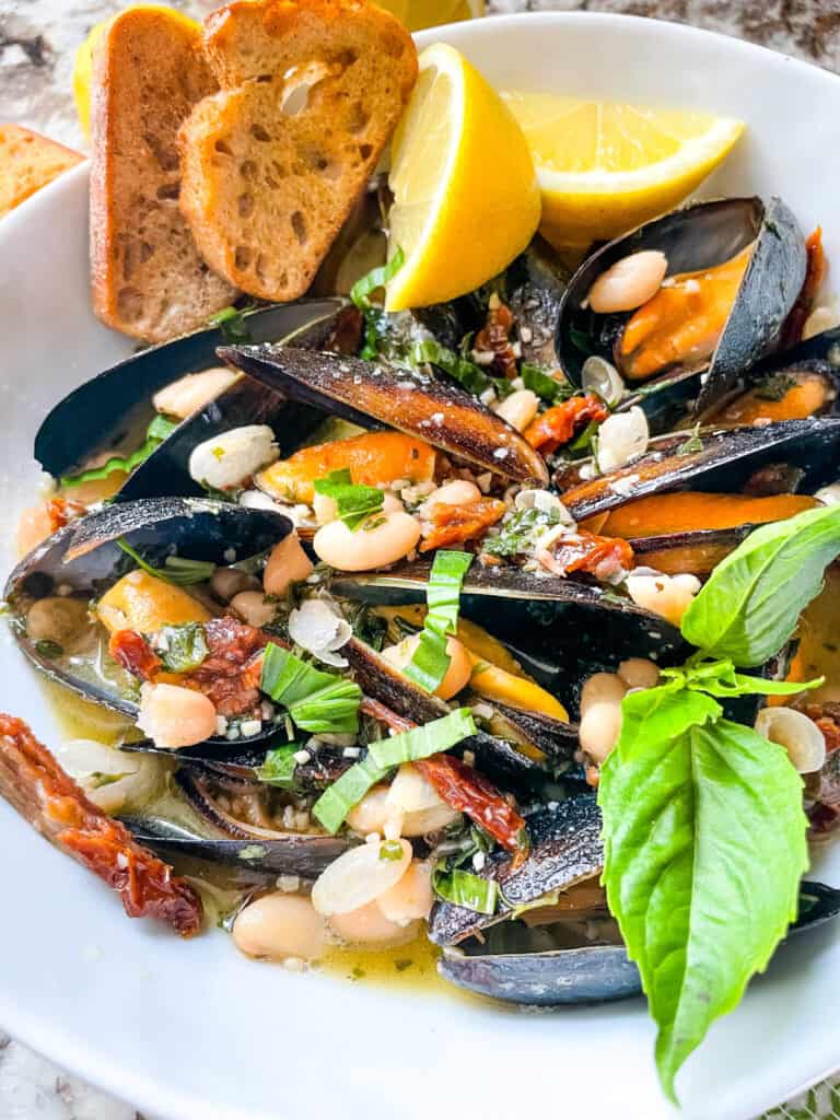 The shellfish and sauce in a bowl with basil