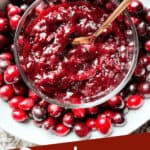 Pin image of Cranberry Jam in a bowl with copper spoon inside larger bowl full of berries