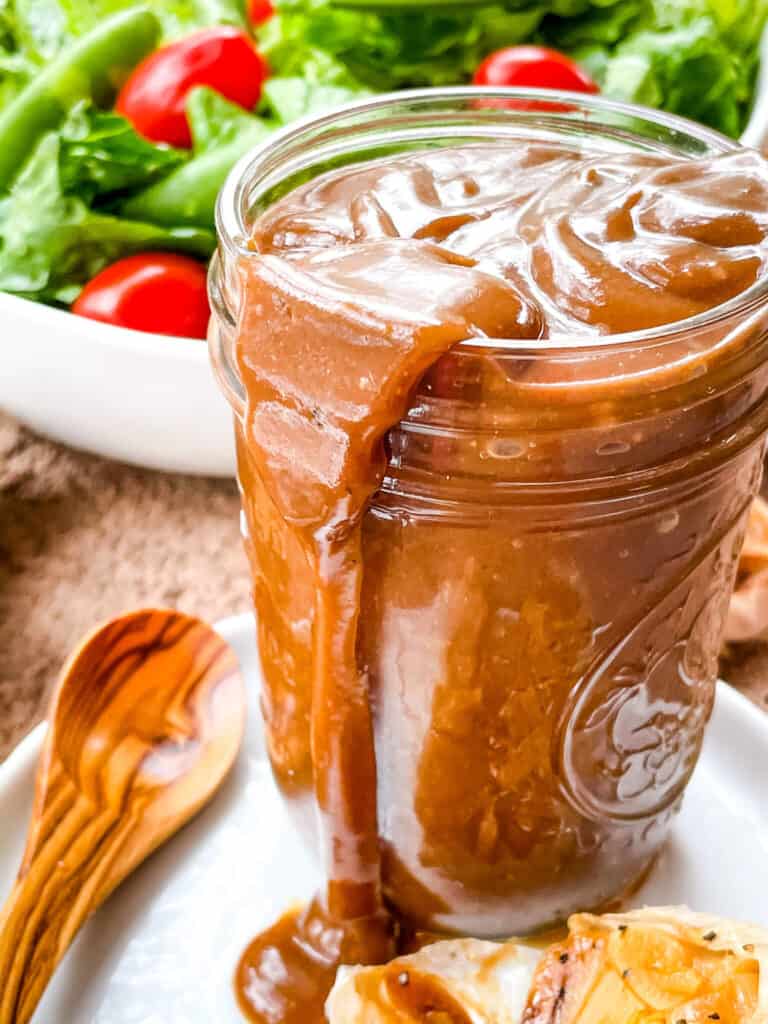 A close up of the jar overflowing with the dressing