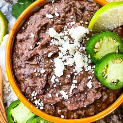 The mashed beans in a bowl with peppers on top